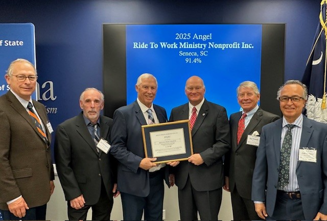 Ride to Work Ministry board with SC Secretary of State Mark Hammond holding award certificate